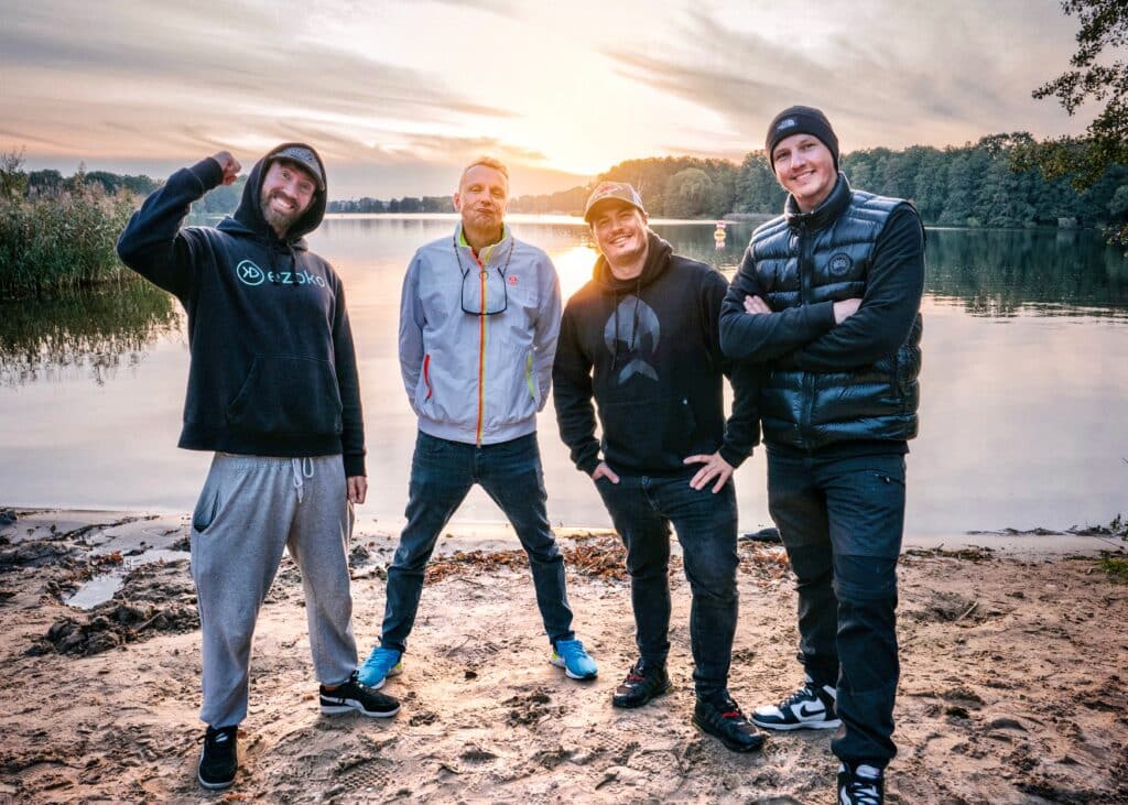 Geschenke für Angler: Ein Teil der Better-Fishing-Jury am Seeufer bei Sonnenuntergang