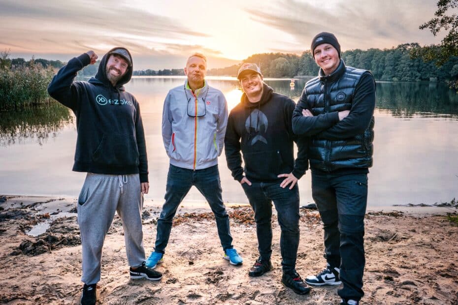 Geschenke für Angler: Ein Teil der Better-Fishing-Jury am Seeufer bei Sonnenuntergang